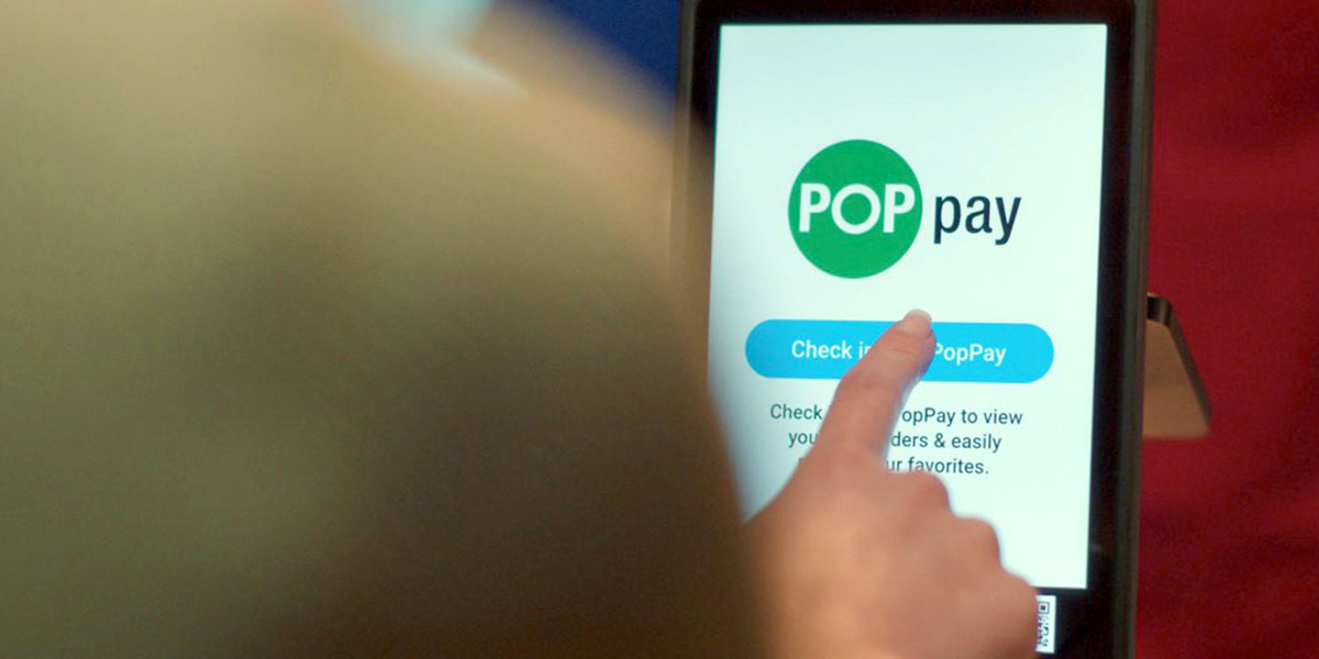 Person using tablet with POP Pay on the screen Person using tablet with POP Pay on the screen