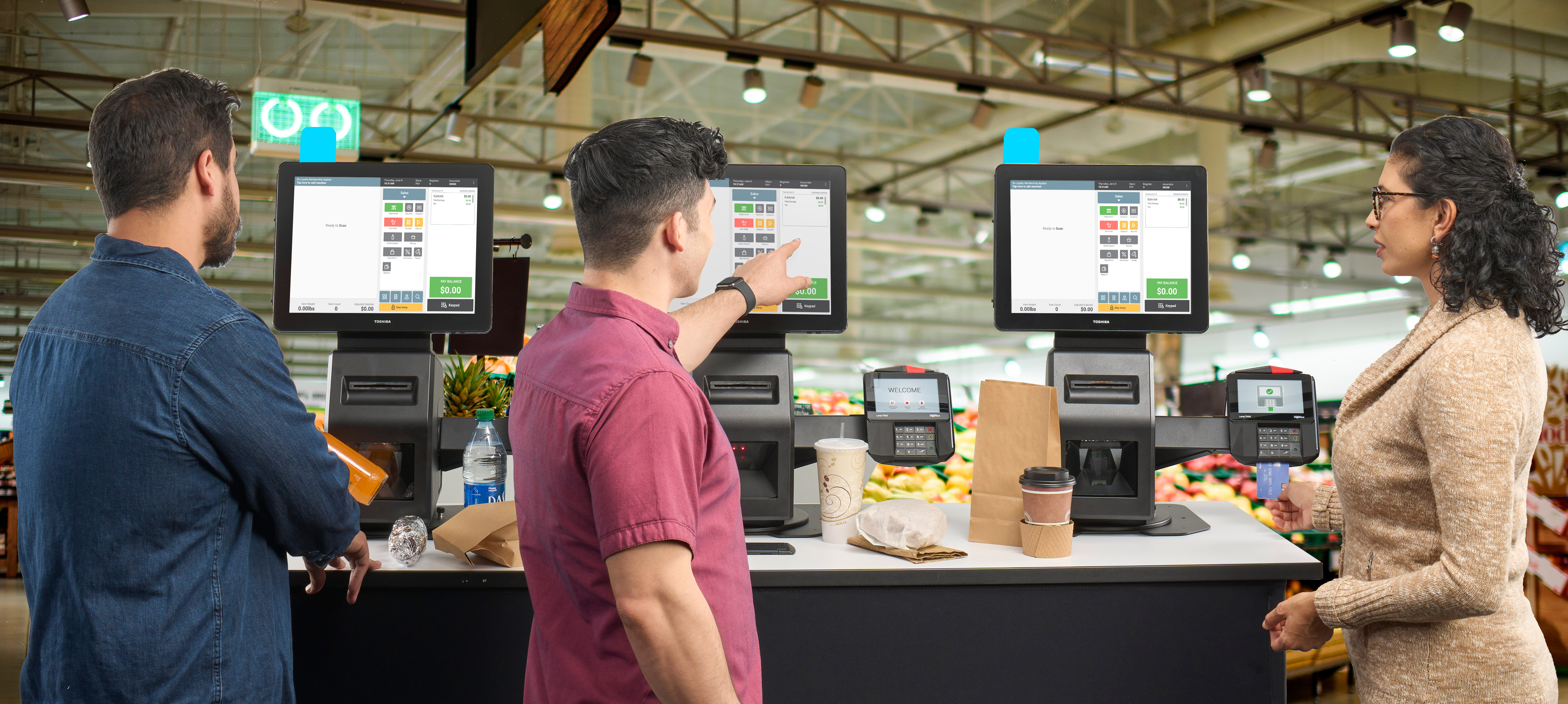 3 people using self checkout 3 people using self checkout