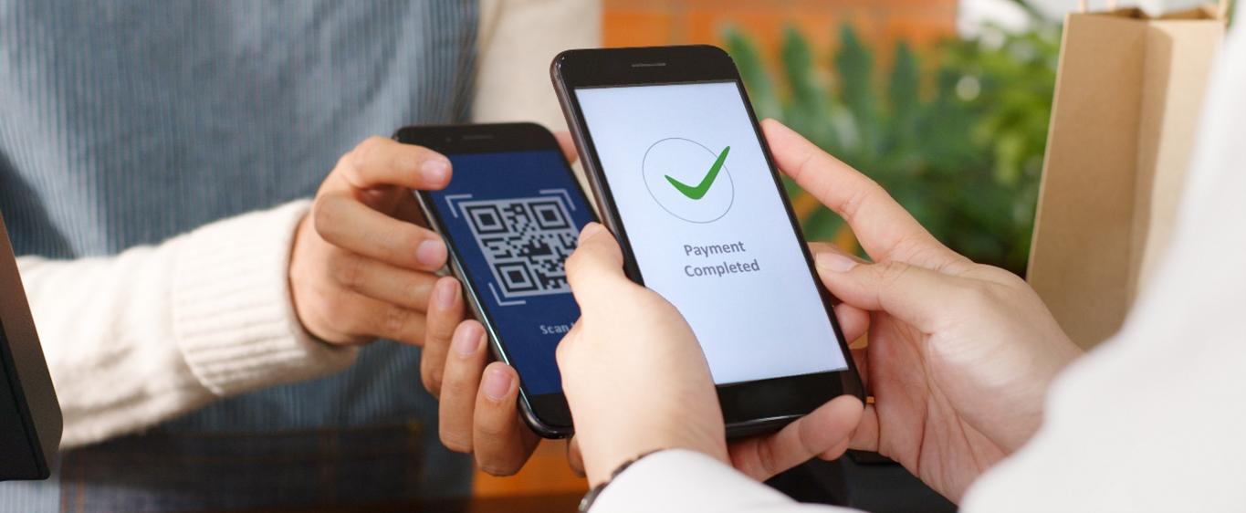 Person using a mobile device to scan and verify a QR code on a second mobile device Person using a mobile device to scan and verify a QR code on a second mobile device